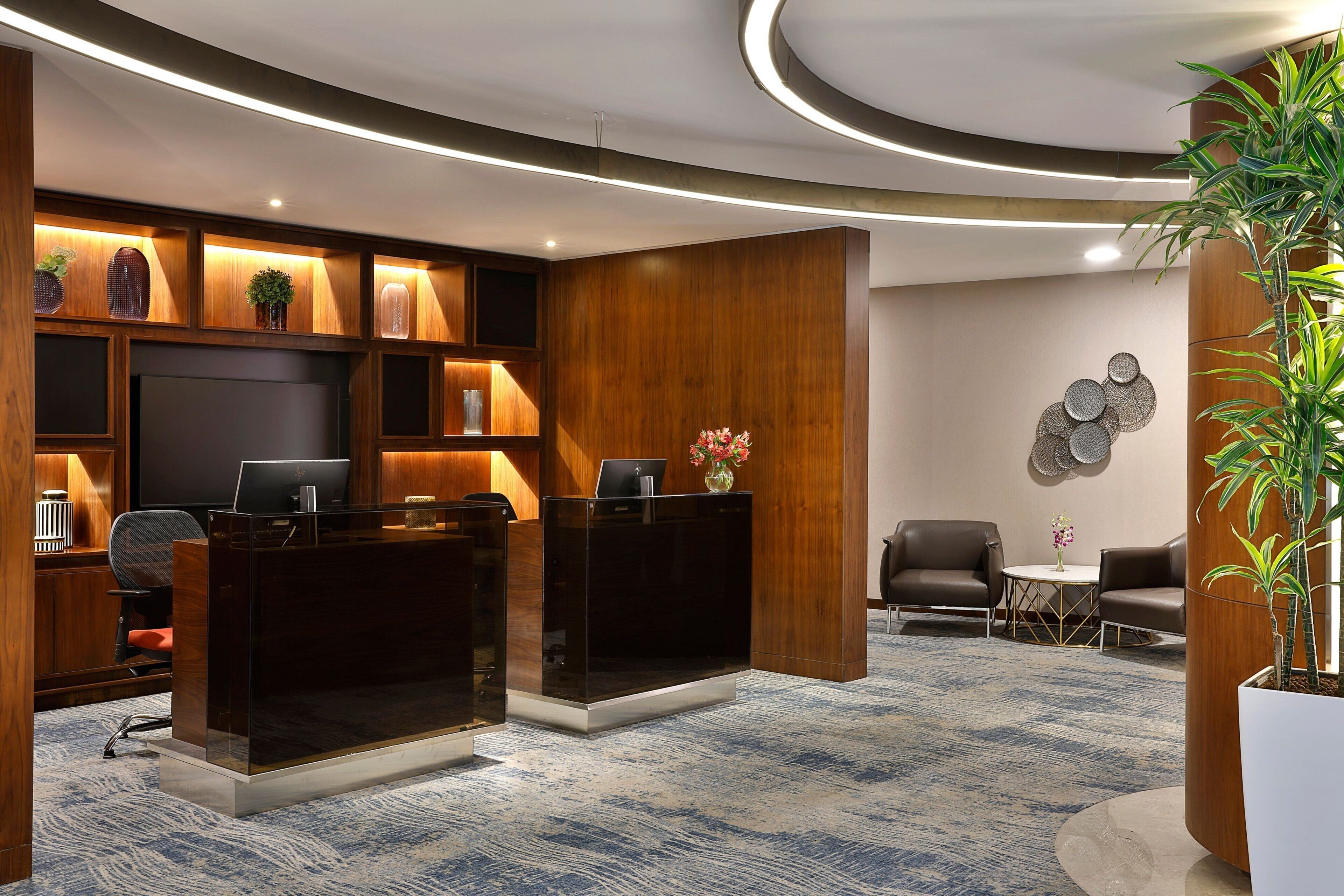 Un área de recepción moderna con mostrador, asientos y elementos decorativos.