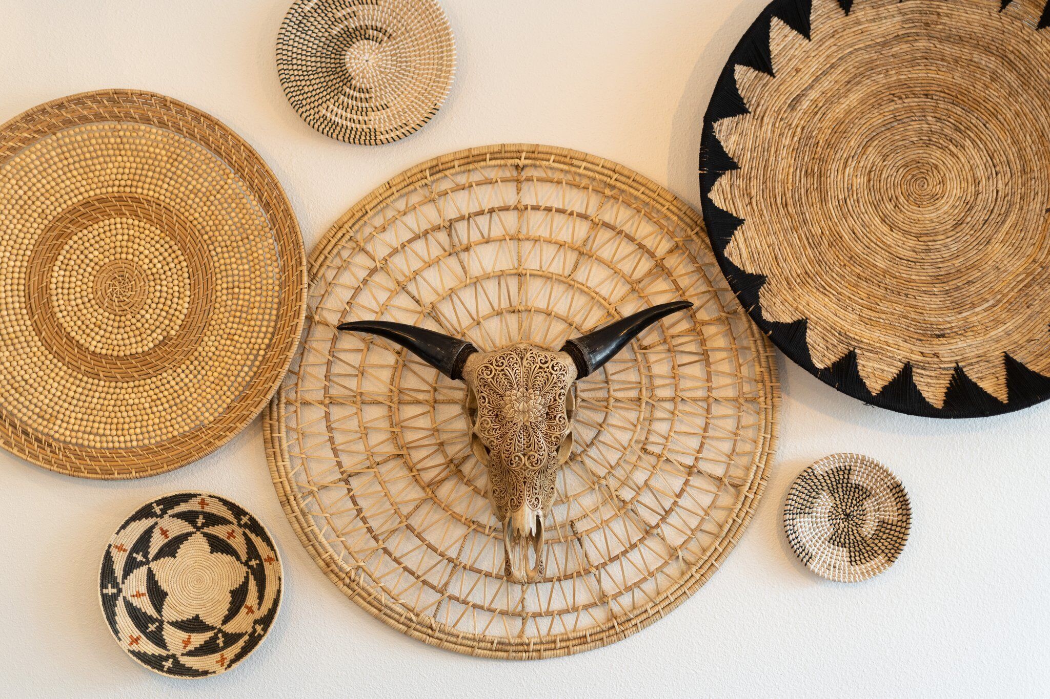 A collection of woven baskets and a decorative item with a bull's head.