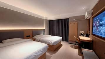 A hotel room with two beds, a desk with a chair, a TV, and a curtain.