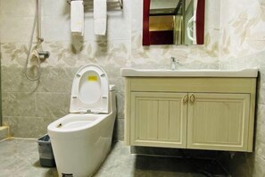 Un baño con inodoro, lavamanos y armario.