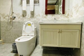 Un baño con inodoro, lavamanos y armario.
