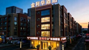 A hotel with a modern facade, multiple floors, and illuminated signage.