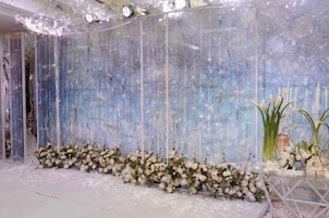 Una habitación con un muro decorativo, un arreglo floral y un piso estampado.