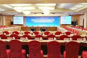 Ein Konferenzraum mit Tischen, Stühlen und Namensschildern, ausgestattet mit Projektoren und Bildschirmen.