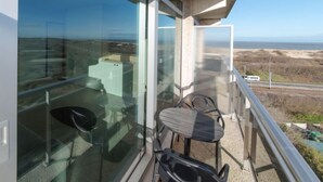 A balcony with a view of the sea, a table, and two chairs. - Astrid 802 with parking by Interhome (Bredene)