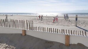 En strand med et træhegn og en betonmur.