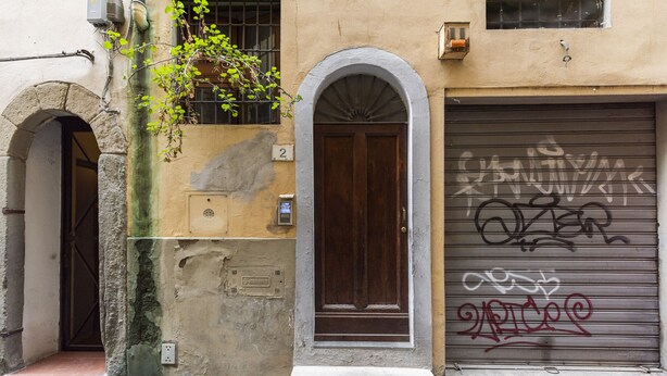 Un edificio con una puerta de garaje cerrada, una puerta de madera y un letrero con el número 2.