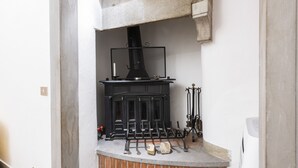 Una chimenea con repisa negra y pared blanca detrás.