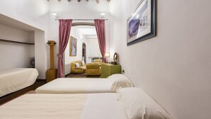 Habitación de hotel con dos camas, un sillón amarillo, un armario verde y un cuadro en la pared.