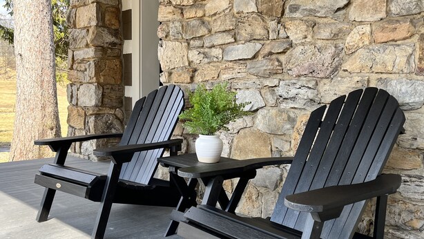Two Adirondack chairs with a stone wall backdrop and a potted plant on a patio. - Charming newly-renovated historic log house near PSU and Spruce Creek (Tyrone)