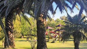 A park with palm trees, a playground, and a gazebo. - Apartment with terrace or balcony (Poggio-Mezzana)