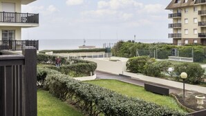A residential building with balconies, a paved courtyard, and a view of the sea. - Les Normandières by Interhome (Cabourg)