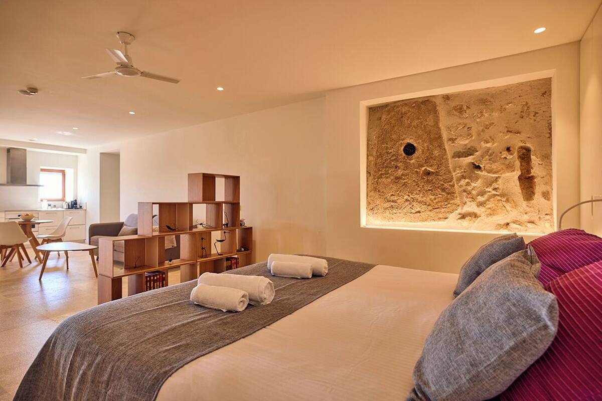 A modern hotel room with a large bed, a desk, and a seating area.