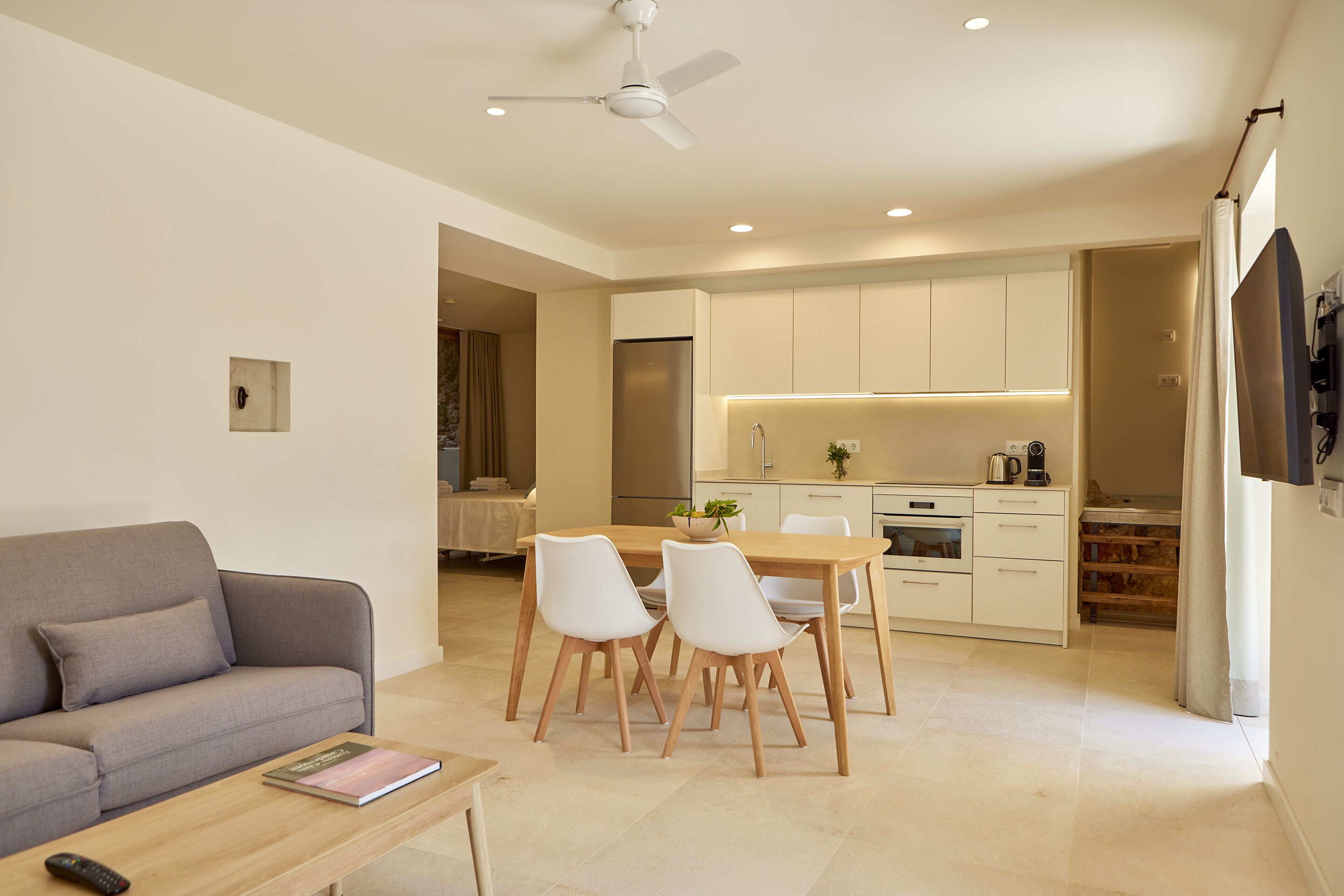 A modern living room with a sofa, coffee table, and dining area with chairs.