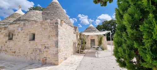 Aprus trullo surrounded by greenery with private pool.