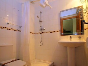 Ein Badezimmer mit Dusche, Toilette und Waschbecken.