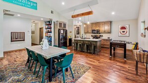 A spacious kitchen with wooden cabinets, a bar area, and a dining table with chairs. - Stargazer Waterfront Luxe Retreat ✨Sand Beach 🎣Awesome Fishing🔥Campfires🛶Kayaks (Mineola)