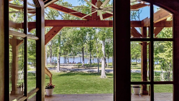 A wooden deck with a view of a lake and trees.
