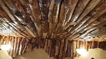 Un intérieur rustique avec des poutres apparentes et un mur à la texture particulière.