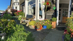 A building with a 'NO VACANCIES' sign, a bench, and various potted plants. - 2 Cambridge Villas (Ambleside)