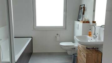 Bathtub, hair dryer, towels, toilet paper
