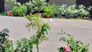 A courtyard with potted plants and a building with a red roof. - Fewo Provinzperle - newly designed - an ideal starting point for your tours (Freckenfeld)