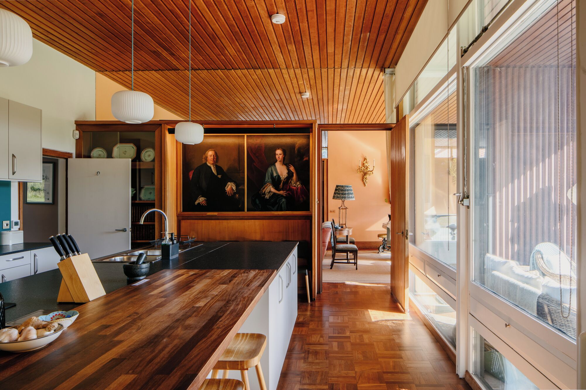 A modern kitchen with wooden cabinetry, a central island, and pendant lighting.