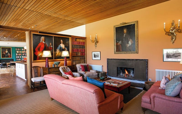 Una sala de estar acogedora con chimenea, estanterías y asientos cómodos.