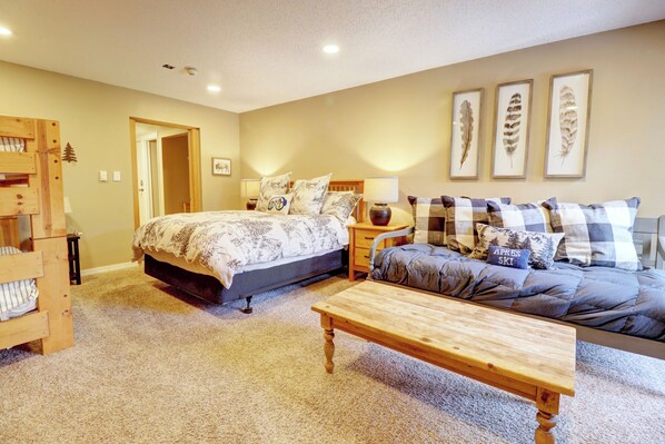 A bedroom with a bed, a sofa, a wooden table, and a wall with feather art. - New Listing! Ski in/out Center Village Hotel Room Lots of bedding CM217 (Copper Mountain)