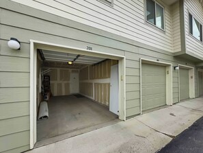A building with three garage doors, numbered 201, 202, and 203.