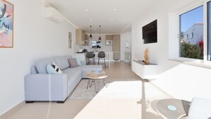A modern apartment with a living area, kitchen, and dining space. - Waterside Village Townhouse (Luz)