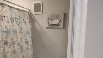 Tina con regadera, toallas, jabón, papel de baño