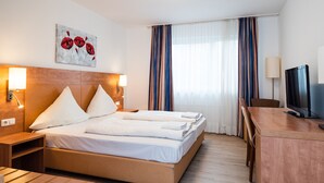 A hotel room with a bed, bedside tables, a desk, a TV, and a painting on the wall. - G & L Hotel (Dortmund)