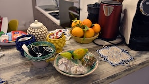 Una encimera de cocina con distintos alimentos, una cafetera y electrodomésticos.