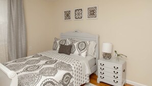 A bedroom with a bed, a nightstand, and three wall-mounted decorative items. - Large 4 Bedroom CT Home Comfy for Longer Stay (Bristol)