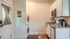 A compact kitchen with a washing machine, microwave, and coffee maker. - Rustic Studio Walkable to Music Row (Nashville)