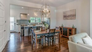 A spacious kitchen with a dining area, wooden flooring, and a modern chandelier. - The Keystone on 3rd - Walkable & Close to Downtown (Nashville)