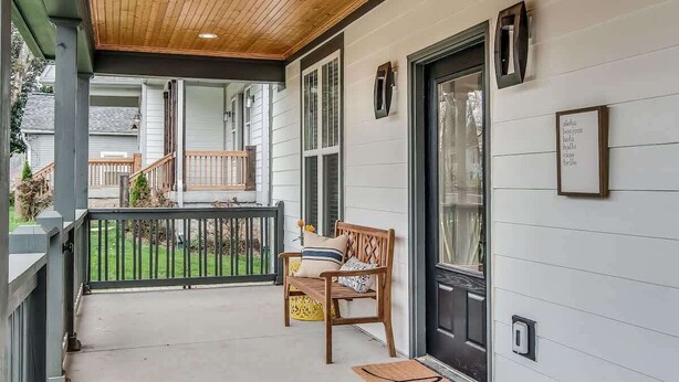 A covered porch with a wooden ceiling, a bench, and a door with a 'hello' sign. - The Sage Estate - Only 6 Minutes from Downtown (Nashville)