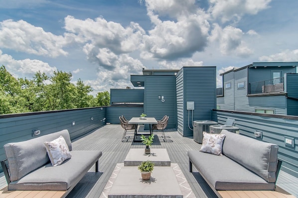 Enjoy a meal or relax on the rooftop terrace with a dining table, sofas, and a coffee table.