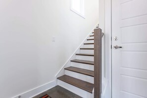A staircase with wooden steps leading to a white door.