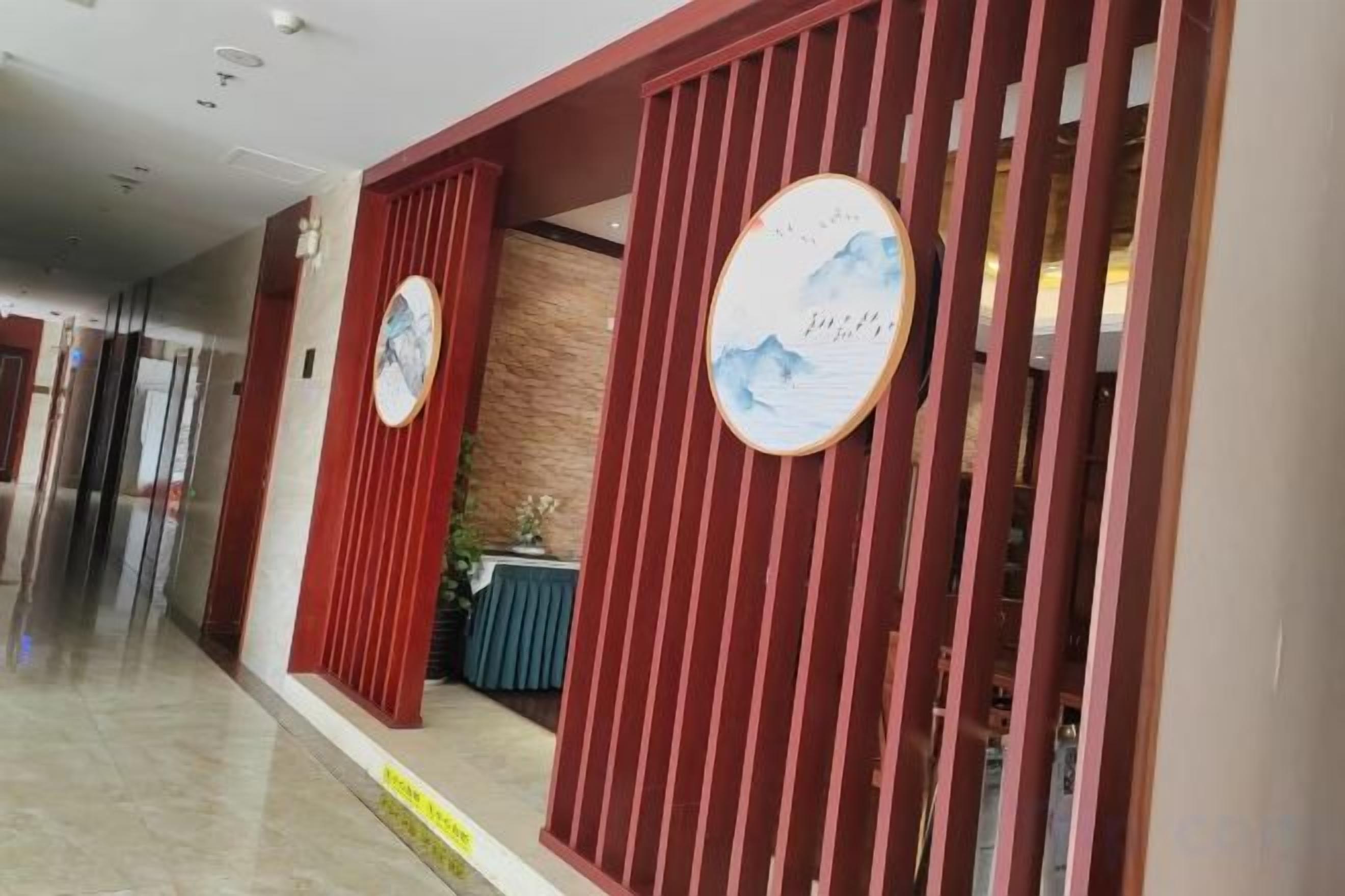 A hotel reception area with a modern design, featuring a reception desk and a waiting area with a view of the hallway.