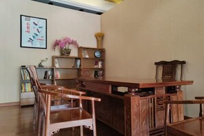 Un bureau en bois traditionnel, avec des chaises, une bibliothèque et un tableau encadré accroché au mur.