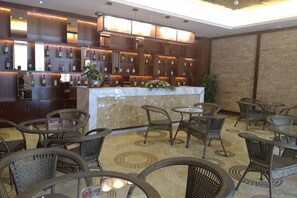 Zona de bar con mostrador, asientos y suelo estampado.