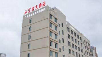 A multi-story hotel building with a flat facade, multiple windows, and a visible name sign.