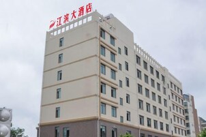 Un edificio de hotel de varios pisos con fachada plana, múltiples ventanas y una señalización visible del nombre.