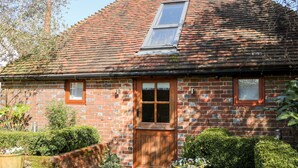 A brick house with a tiled roof, a wooden door, and a window.
