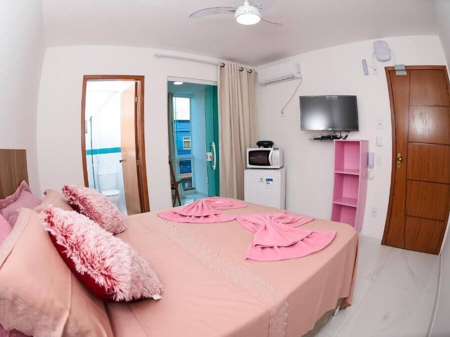 Un dormitori amb llit, televisió, microones i armari.