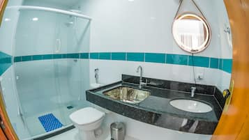 Une salle de bain moderne avec une douche à parois de verre, des toilettes blanches, un lavabo avec un miroir et des touches de couleur turquoise sur les murs.
