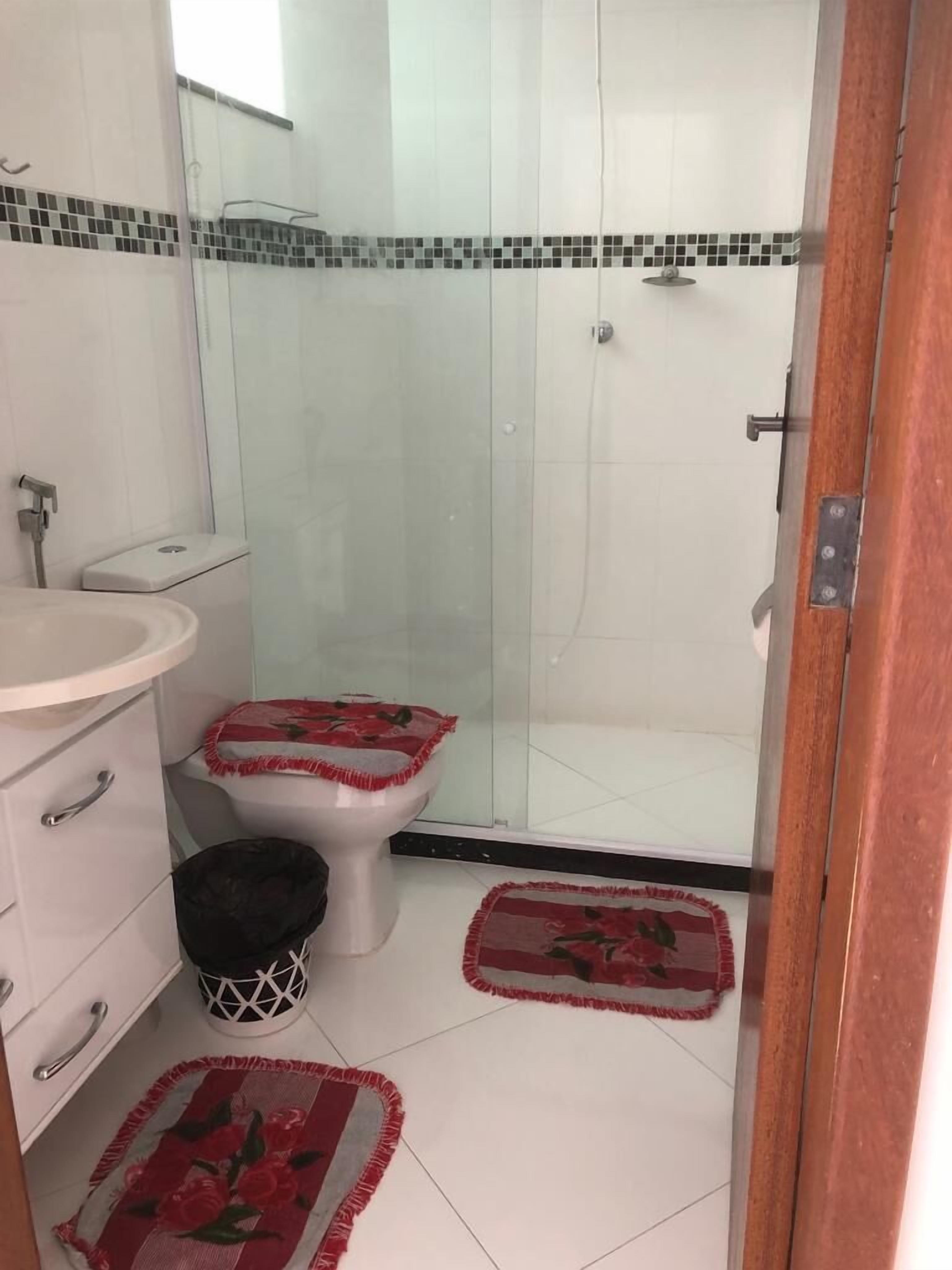Een badkamer met toilet, wastafel en douche.