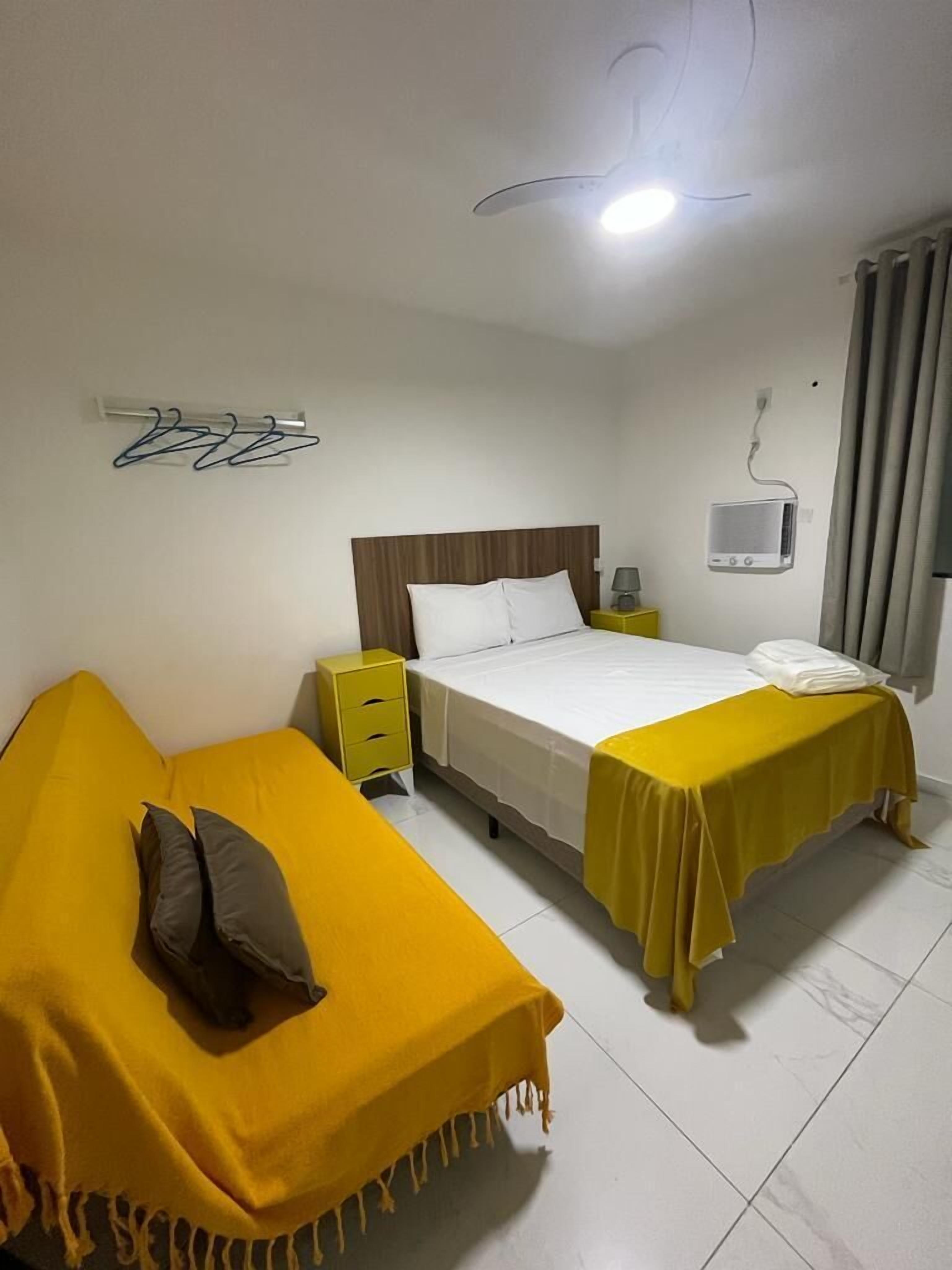 Una habitación de hotel con una cama, una mesita de noche, una lámpara, un televisor y un adorno en la pared.